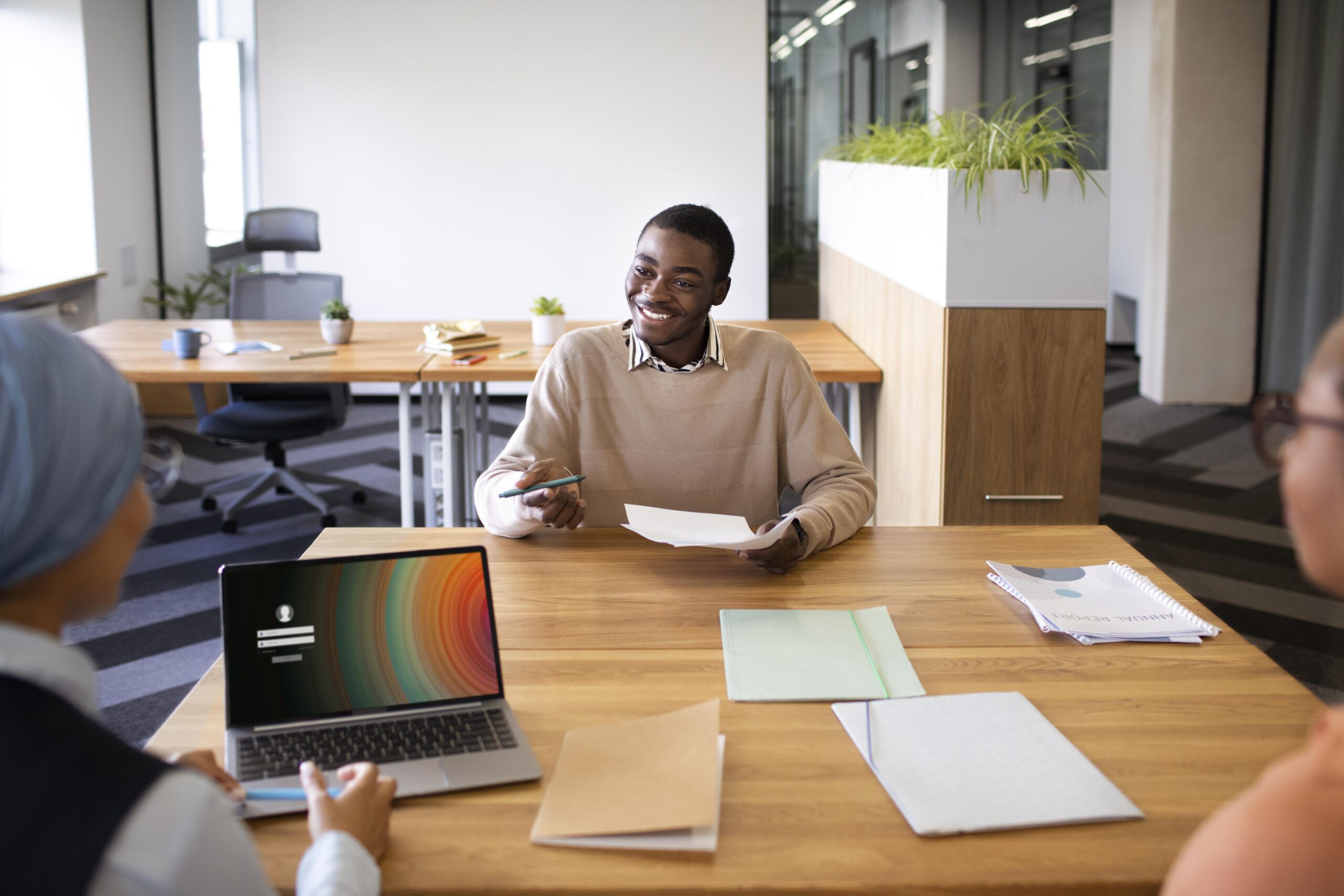 man sitting down office job interview desk with his employers