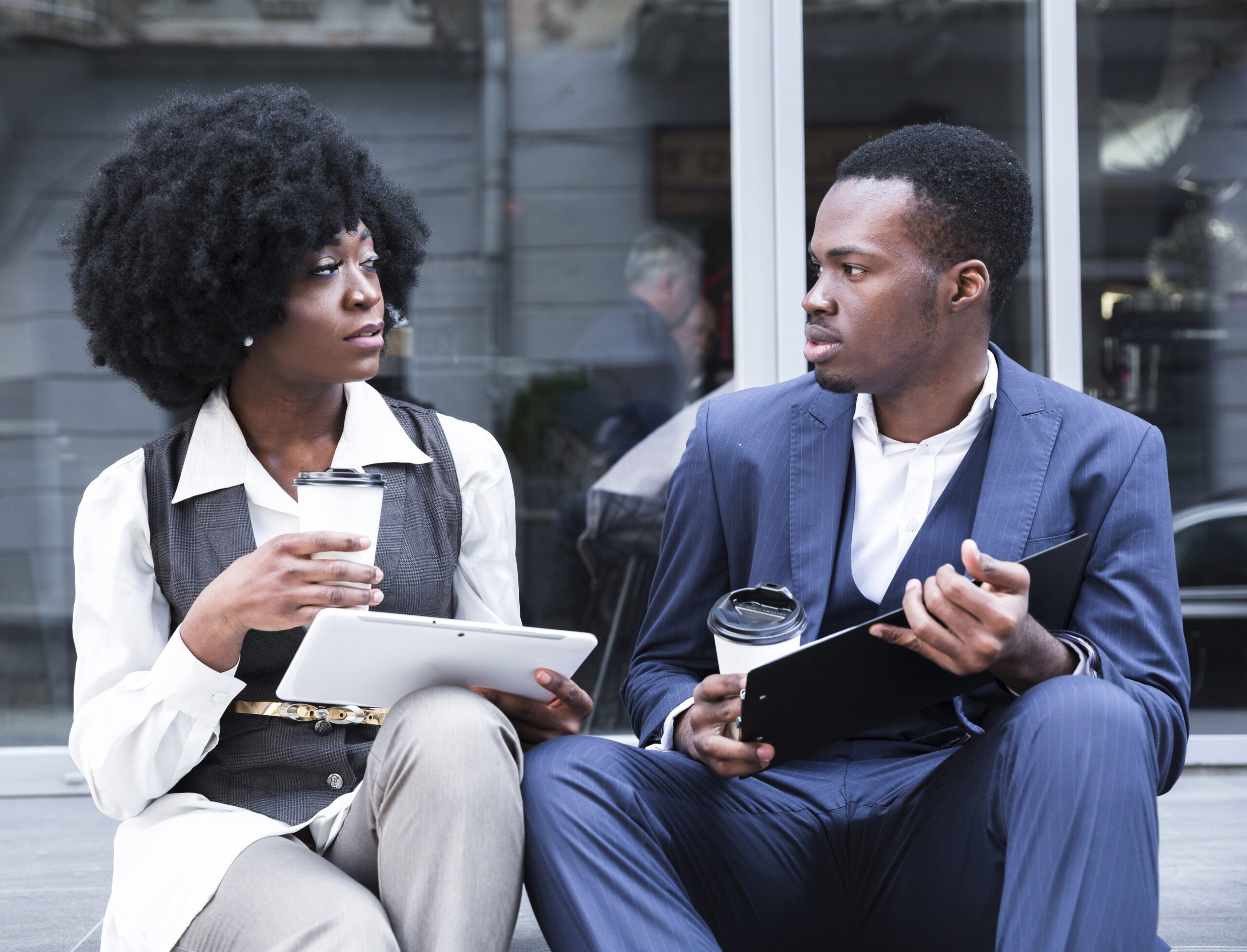 portrait young african businessman businesswoman sitting together outside office ()