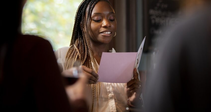 smiley woman reading card close up