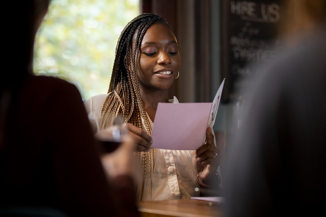 smiley woman reading card close up